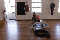 Boxerin bindet Schnürsenkel im Fitnessstudio — Stockfoto