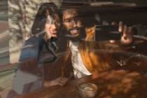 Счастливая пара делает селфи в кафе — стоковое фото