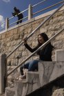 Улыбающаяся женщина делает селфи на лестнице — стоковое фото