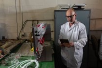 Чоловічий працівник використовує цифровий планшет на скляній фабриці — стокове фото