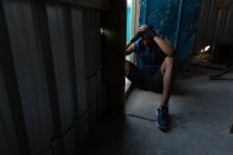 Cansado boxeador masculino relajándose en el club de boxeo - foto de stock
