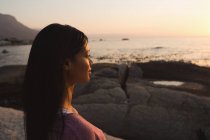 Вид сбоку на женщину, стоящую у моря — стоковое фото