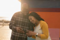 Glückliches Paar nutzt Handy-Promenade — Stockfoto