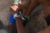 Close-up of male athlete using smartwatch near beach — Stock Photo