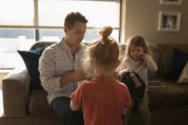 Girl looking at her father and sister in living room at home — Stock Photo