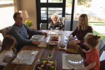 Родина багатьох поколінь, що мають їжу на обідньому столі вдома — стокове фото