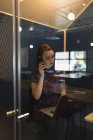 Бізнес-леді розмовляє на мобільному телефоні за столом в офісі — стокове фото