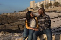 Glückliches Paar sitzt am Strand — Stockfoto