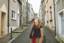 Redhead woman standing on alley street — Stock Photo