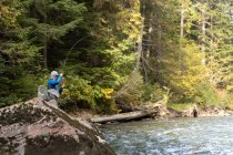 Fisherman fly fishing in river on sunny day — Stock Photo