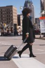 Mulher com saco de bagagem andando na cidade em um dia ensolarado — Fotografia de Stock