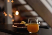Glass of orange juice on worktop in kitchen at home — Stock Photo