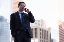 Empresario hablando por teléfono móvil en balcón en el hotel - foto de stock