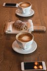 Primer plano del café y la comida dulce en la mesa en la cafetería - foto de stock