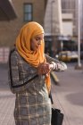 Hijab mujer usando reloj inteligente en la ciudad - foto de stock