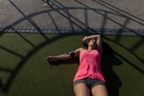 Жінка-бігунка розслабляється в парку в сонячний день — стокове фото