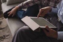 Крупный план дедушки и внучки с помощью цифрового планшета на диване в гостиной дома — стоковое фото