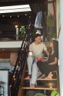 Пара взаємодіє один з одним, маючи каву в сходах вдома — стокове фото