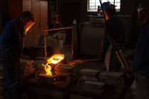 Trabalhadores que despejam metal fundido de frascos para moldes em fundição — Fotografia de Stock