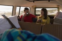 Couple having coffee in van on road trip — Stock Photo