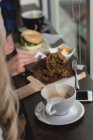 Coffee and food on table in cafe — Stock Photo