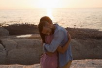 Романтическая пара, обнимающая друг друга у моря — стоковое фото