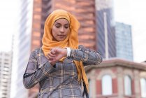 Hijab donna utilizzando orologio intelligente in città — Foto stock