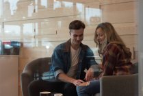 Jeune couple interagissant les uns avec les autres dans un café — Photo de stock