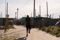 Homme athlète jogging près du village par une journée ensoleillée — Photo de stock