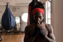 Junger Boxer blickt im Fitnessstudio in die Kamera — Stockfoto