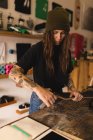 Junge Frau repariert Skateboard in Werkstatt — Stockfoto