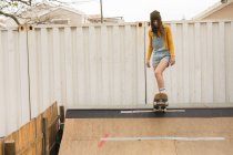 Junge Skateboarderin skatet auf Skateboard-Rampe am Skateboard-Platz — Stockfoto