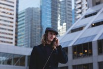 Чоловік розмовляє по мобільному телефону під час прогулянки по вулиці в місті — стокове фото