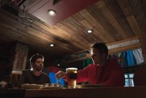 Jovens amigos desfrutando de suas bebidas no pub — Fotografia de Stock