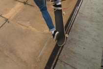 Primo piano dello skateboarder che pattina sulla rampa dello skateboard al campo da skateboard — Foto stock