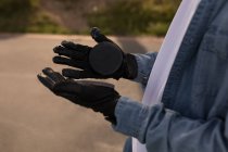 Close-up of skateboarder looking at skateboard gloves — Stock Photo