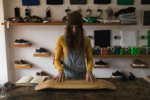 Молодая женщина осматривает скейтборд в мастерской — стоковое фото