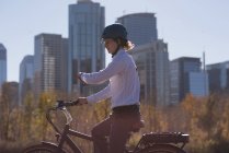 Homem verificando o tempo ao andar de bicicleta na estrada na cidade — Fotografia de Stock