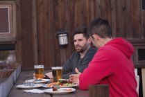 Friends talking with each other while having drinks at outdoor pub — Stock Photo