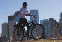 Young man riding bicycle on the road in the city — Stock Photo