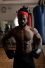 Porträt eines männlichen Boxers, der mit den Händen auf den Hüften im Fitnessstudio steht — Stockfoto