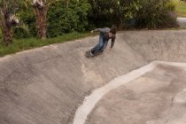 Jeune homme skateboard dans le parc de skateboard — Photo de stock