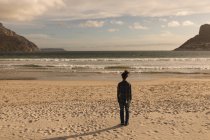 Rückansicht eines Mannes, der an einem sonnigen Tag am Strand steht — Stockfoto