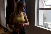 Молода жінка-боксер в обгортці рук у фітнес-студії — стокове фото