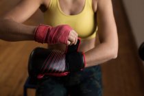 Close-up de boxeador feminino usando luvas de boxe no estúdio de fitness — Fotografia de Stock