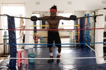 Без сорочки чоловічий боксер стоїть в боксерському кільці в фітнес-студії — стокове фото