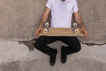 Low section of man relaxing with skateboard at skateboard park — Stock Photo