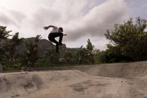 Young man skateboarding in skateboard park — Stock Photo