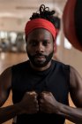 Portrait of male boxer forming hand fist in fitness studio — Stock Photo
