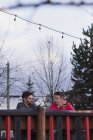 Молодые друзья наслаждаются напитками в пабе на открытом воздухе — стоковое фото